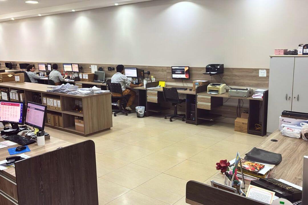 Equipe de contabilidade trabalhando em estações organizadas dentro do escritório amplo.